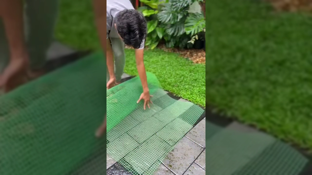 Foto de um homem criando uma torre de orquídeas vertical usando tela verde e substrato, com diversas orquídeas coloridas já plantadas / Instagram @tocos_e_cia