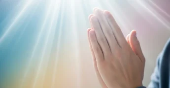 Mão em oração com luz suave, simbolizando fé e bênçãos matinais.
